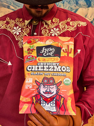 A person in a red embroidered shirt holds a Maurices Must-haves Box from LesserEvil Snacks.