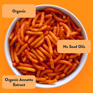 A bowl of Cowboy Cheddar Cheezmos by LesserEvil on an orange background—organic, no seed oils, and made with organic annatto extract for stellar snacking.