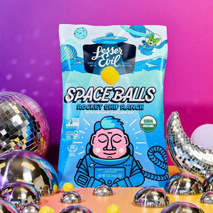A vibrant bag of SpaceBalls Rocket Ship Ranch Space Balls stands against a disco-ball and crescent-moon background with a pink-orange gradient.