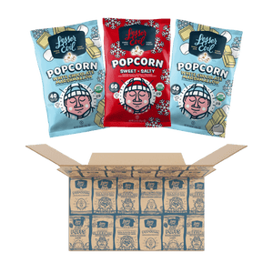 Three bags of LesserEvil Snacks popcorn (two White Chocolate & Matcha, one Sweet & Salty) are displayed above a Holiday Popcorn Box with festive packaging.