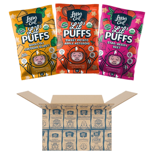 Three colorful bags of LesserEvil Snacks Stellas Stars Lil Puffs sit above an open Stellas Stars Lil Puffs Box with branded packaging inside.