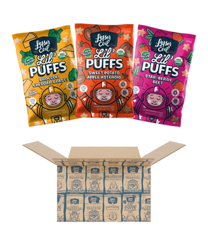 Three colorful bags of LesserEvil Snacks Stellas Stars Lil Puffs sit above an open Stellas Stars Lil Puffs Box with branded packaging inside.