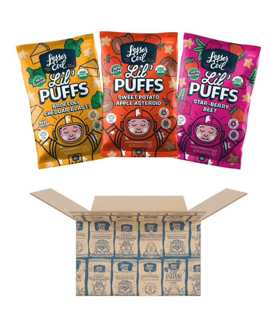 Three colorful bags of LesserEvil Snacks Stellas Stars Lil Puffs sit above an open Stellas Stars Lil Puffs Box with branded packaging inside.