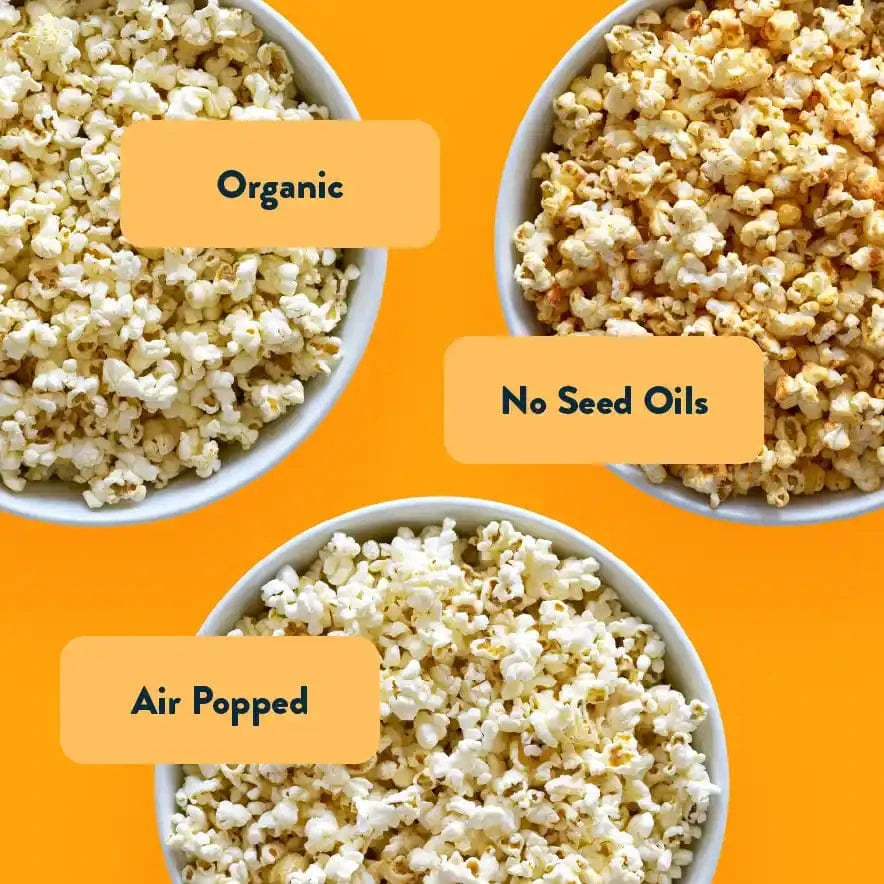 Three bowls of popcorn on an orange background, labeled Big Flavor Popcorn Box by LesserEvil Snacks, No Seed Oils, and Air Popped.
