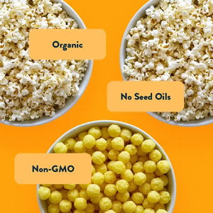 Three bowls on an orange background: two with LesserEvil Snacks Dairy Good Snacks Box (Organic, No Seed Oils) and one Space Balls bowl (Non-GMO yellow puffs).