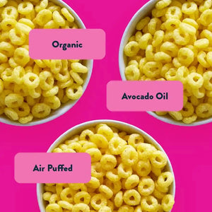Three bowls of yellow cereal loops on pink with Organic, Avocado Oil, Air Puffed labels—Dotties Delights Cosmic Rings Box by LesserEvil Snacks, a perfect snack for Berry Blast fans.