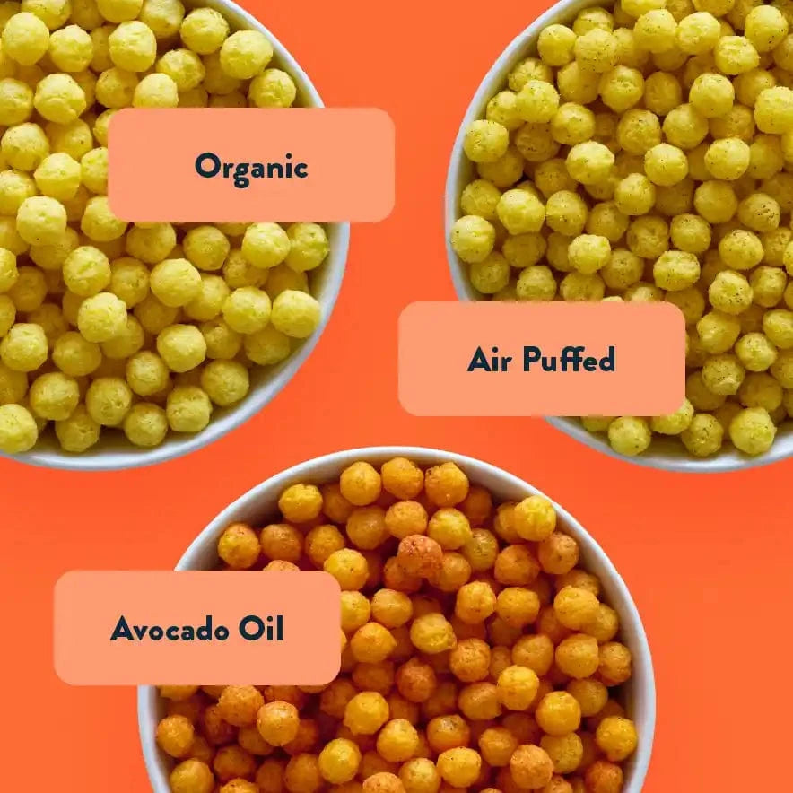Three bowls of yellow puffed snacks—Ziggys Stars Space Balls by LesserEvil Snacks—sit on an orange background.