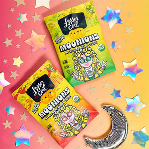 Two colorful bags of LesserEvil Hyperspace Hot Onion Moonions rest on a starry, rainbow gradient background with holographic stars and a disco moon.