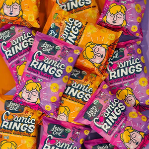 Boxes of LesserEvil Snacks Dotties Delights Cosmic Rings display vibrant packaging with playful cartoon faces and bold text for a fun snack time.