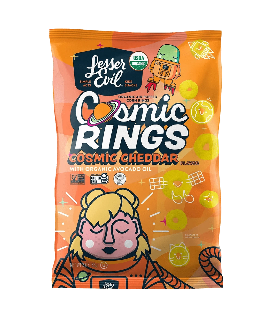 A bright orange bag of LesserEvil Cosmic Cheddar Cosmic Rings vegan snacks features space-themed graphics and a cartoon astronaut with cheese rings.