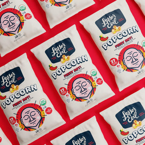 LesserEvil Fiery Hot Organic Popcorn bags are arranged diagonally on a bright red background.