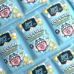 Bags of LesserEvil White Chocolate Marshmallow popcorn, with cartoon-faced packaging, are arranged on a light blue background.
