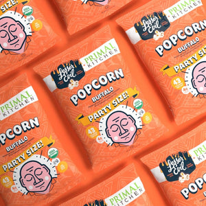 A group of LesserEvil Snacks Primal Kitchen Buffalo Popcorn bags made with clean ingredients.