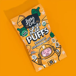 A box of Stellas Stars Lil’ Puffs by LesserEvil Snacks on an orange background, with fun broccoli, cheese, and cartoon child-in-spacesuit graphics.
