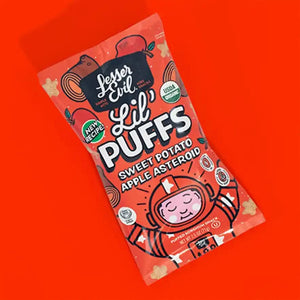 A box of Stellas Stars Lil Puffs by LesserEvil Snacks features playful space-themed graphics and a cartoon astronaut on an orange background.