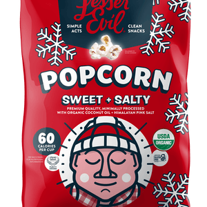A festive red bag of LesserEvil Sweet + Salty Popcorn with snowflakes; a holiday snack made with organic cane sugar and only 60 calories per cup.