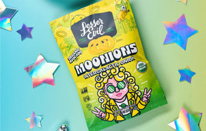 A pastel-colored bag of LesserEvil Intergalactic Onion Moonions features a cartoon, stars, and holographic star stickers.