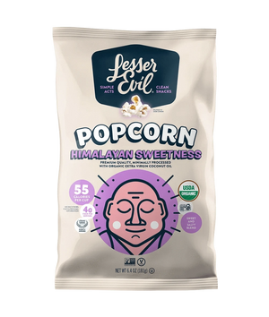 A bag of OrganicPopcorn Himalayan Sweetness Gourmet Popcorn, made with organic cane sugar and Himalayan Pink Salt, in light purple and beige packaging with a cartoon face.