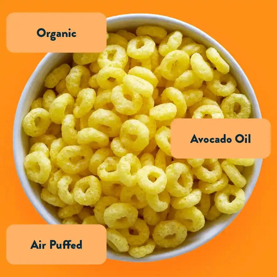 A bowl of LesserEvil Cosmic Cheddar Cosmic Rings, non-dairy snacks with avocado oil, air-puffed, and organic, on an orange background.