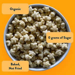 A bowl of Broccoli Cheddar Blast Lil Puffs by LesserEvil on an orange background, labeled Organic, 0g sugar, Baked Not Fried—tasty alone or with cheddar or broccoli.