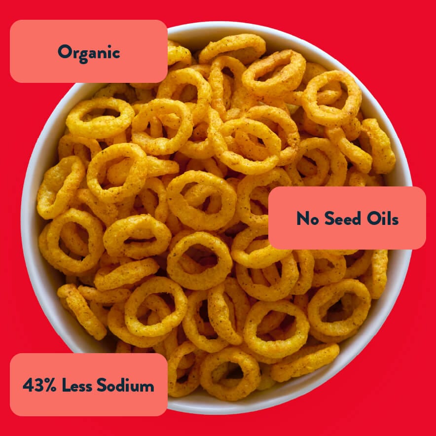 A bowl of LesserEvil Hyperspace Hot Onion Moonions, yellow rings made with avocado oil; Organic, No Seed Oils, 43% Less Sodium.