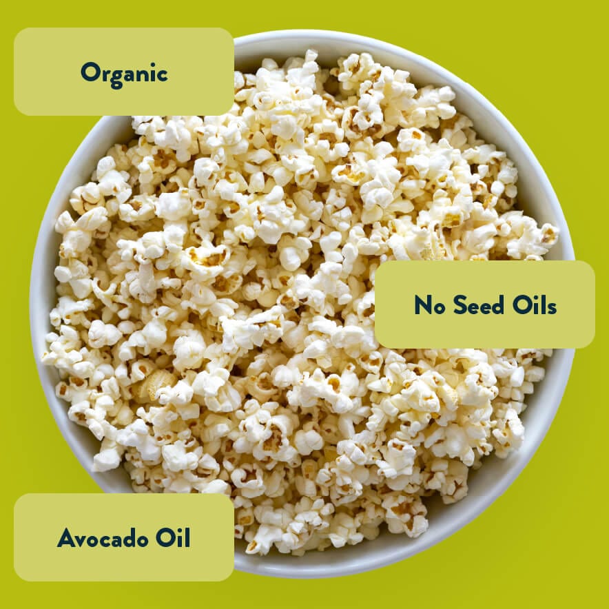 A bowl of Avocado-licious Organic Popcorn by LesserEvil on a green background, labeled: Vegan Snack, No Seed Oils, Avocado Oil, Himalayan Pink Salt.