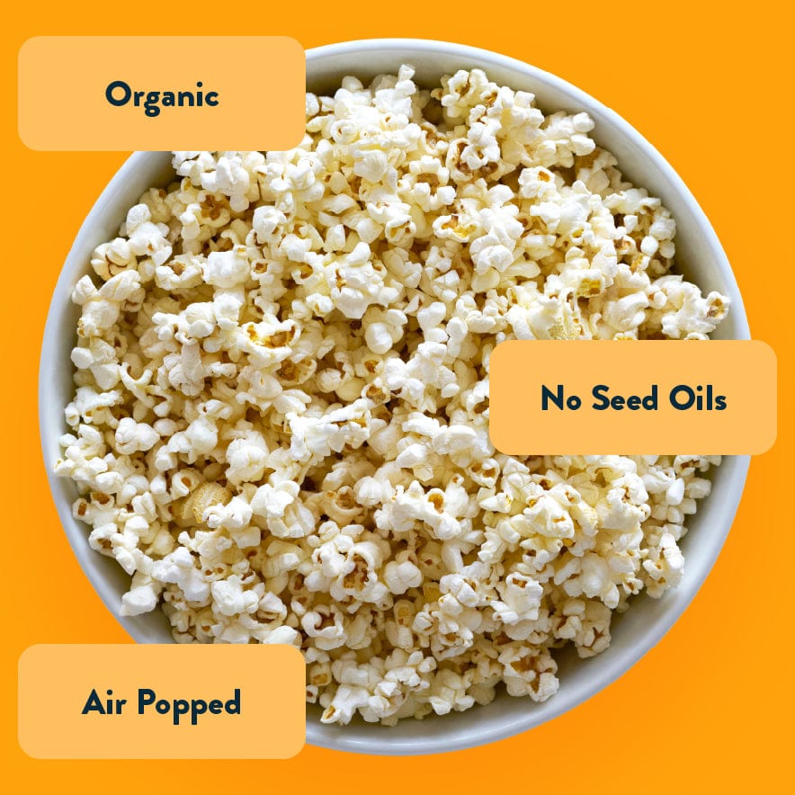 A white bowl of OrganicPopcorn Real Organic Cheddar Popcorn on yellow background, labeled: Organic, Air Popped, No Seed Oils.