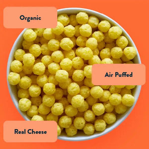 A bowl of SpaceBalls Real Organic Cheddar Space Balls—organic cheese puffs—on an orange background.