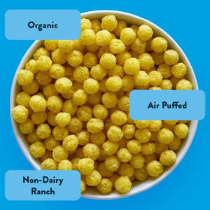 A bowl of yellow, round SpaceBalls Rocket Ship Ranch snacks labeled Organic and Air Puffed sits on a bright blue background, promising cosmic deliciousness.