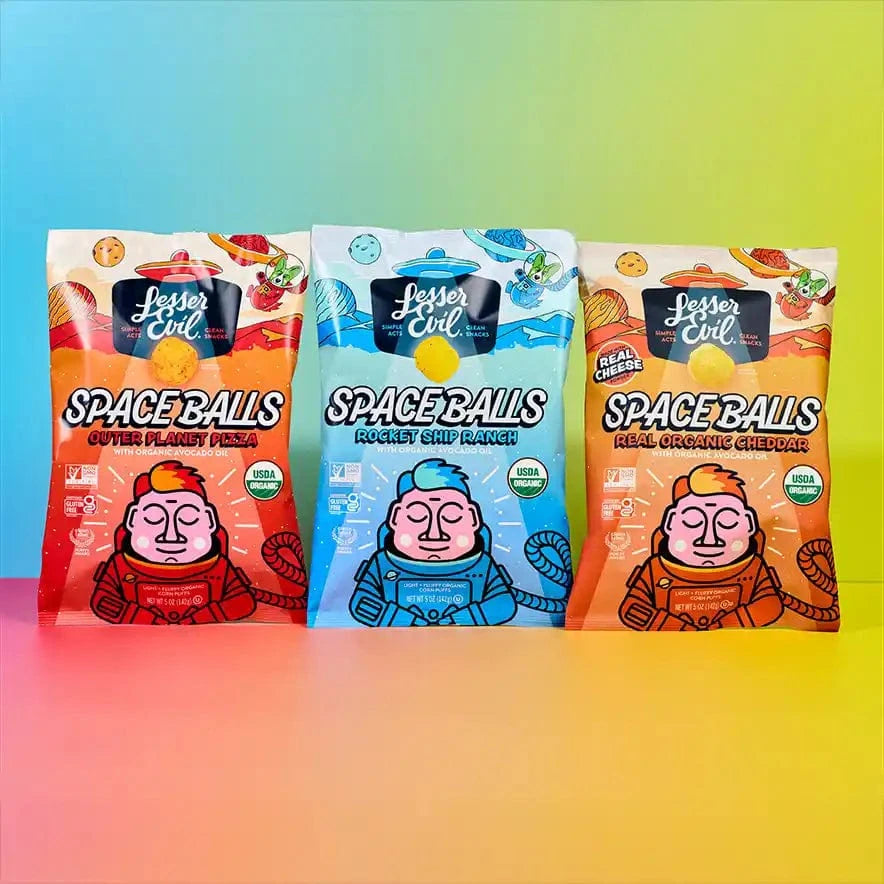Three Ziggys Stars Space Balls Boxes from LesserEvil Snacks stand side by side on a vibrant, rainbow-gradient background.