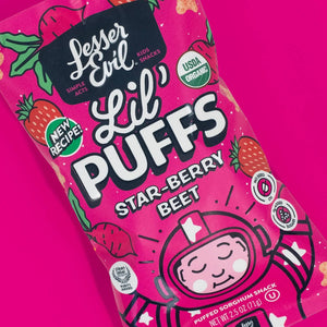 A bright pink bag of LesserEvil Star-Berry Beet Lil Puffs, a berrylicious snack with 0g added sugar, cartoon astronaut, and USDA Organic and New Recipe labels.