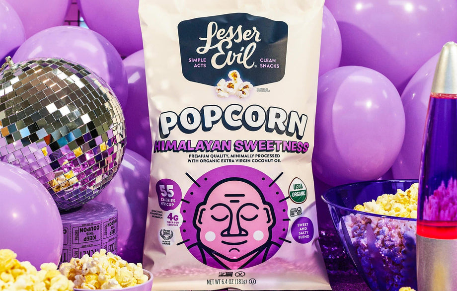 A bag of OrganicPopcorn Himalayan Sweetness Gourmet Popcorn is surrounded by purple balloons, a disco ball, and a purple lava lamp.