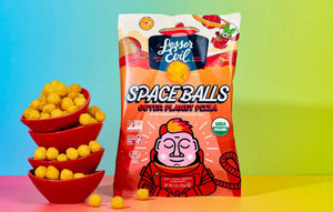 A vibrant bag of SpaceBalls Outer Planet Pizza Space Balls stands beside red bowls of dairy-free cheese balls on a colorful background.
